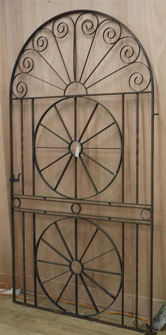 A round arch wrought iron gate W.118cm. H.223cm.